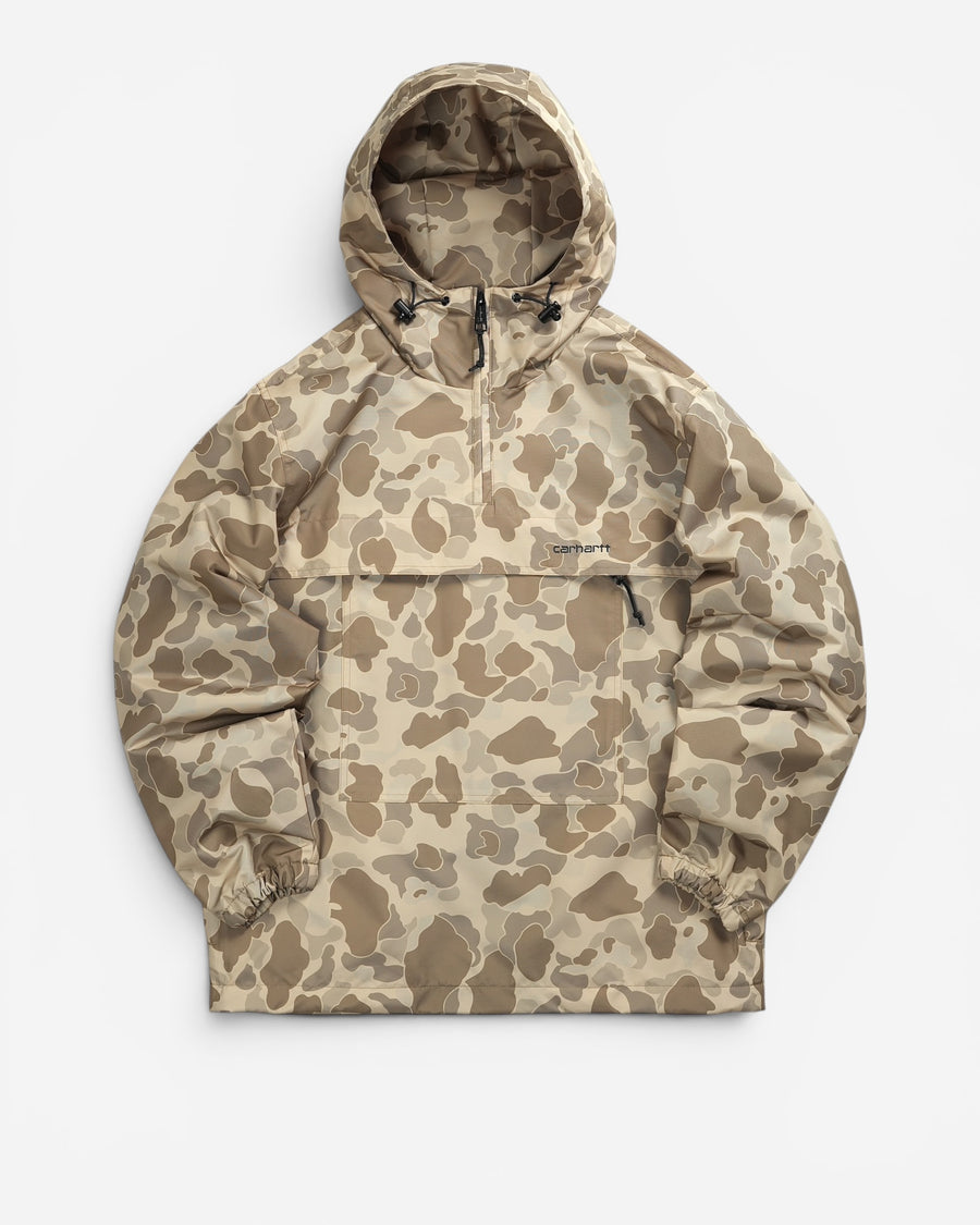 Бежево-коричневий камуфляжний анорак Carhartt WIP з капюшоном на затяжках, високим коміром на блискавці та чорним вишитим написом бренду.