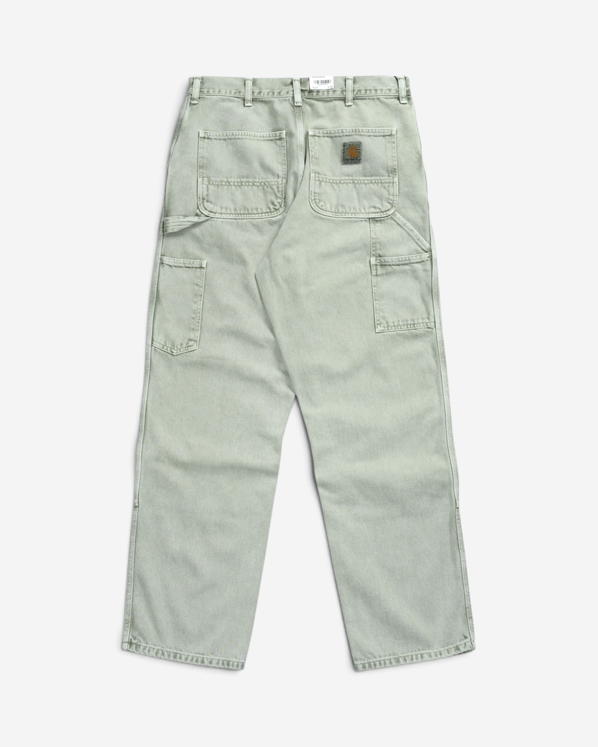 Світло-зелені робочі штани Carhartt WIP Double Knee Pant, вигляд ззаду, з утилітарними робочими кишенями, потертим ефектом та квадратним логотипом бренду.