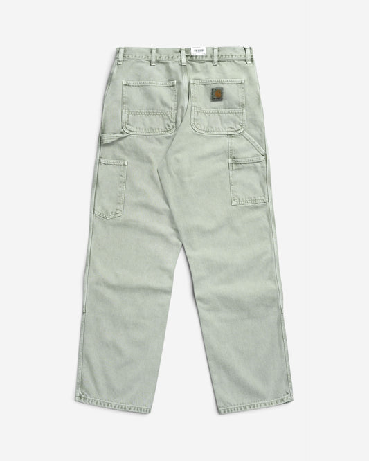 Світло-зелені робочі штани Carhartt WIP Double Knee Pant, вигляд ззаду, з утилітарними робочими кишенями, потертим ефектом та квадратним логотипом бренду.