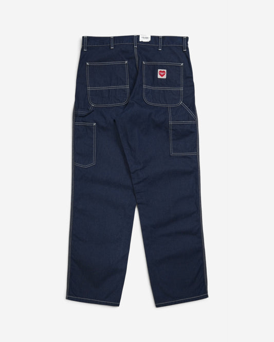 Темно-сині джинси Carhartt WIP Single Knee Pant, вигляд ззаду, з великими кишенями, контрастною білою строчкою, петлею для інструментів та нашивкою у формі червоного серця.