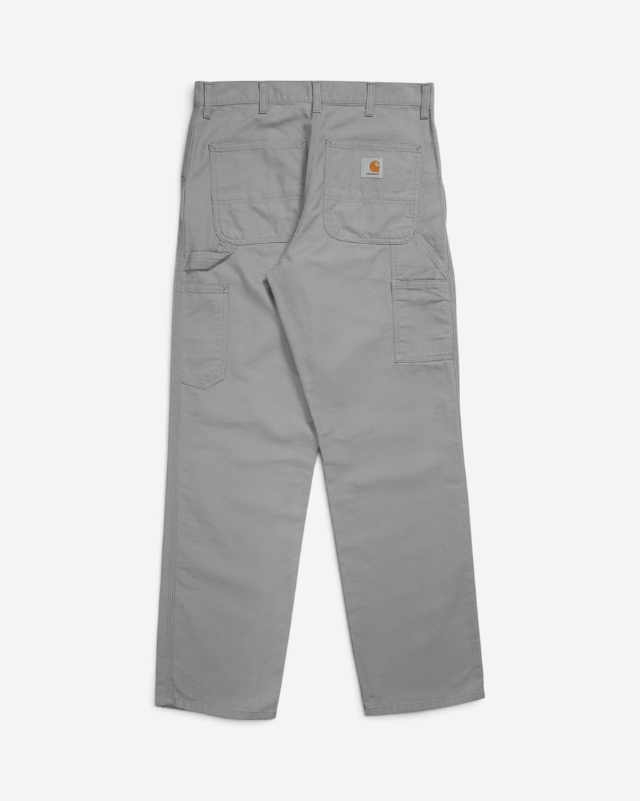 Сіро-бежеві робочі штани Carhartt WIP Single Knee Pant, вигляд ззаду, з великими накладними кишенями, інструментальною петлею та фірмовою нашивкою бренду.
