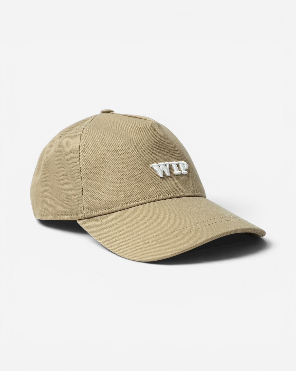 Бежева бавовняна кепка Carhartt WIP із твердим вигнутим козирком та великою об'ємною білою вишивкою літер WIP на фронтальній панелі.