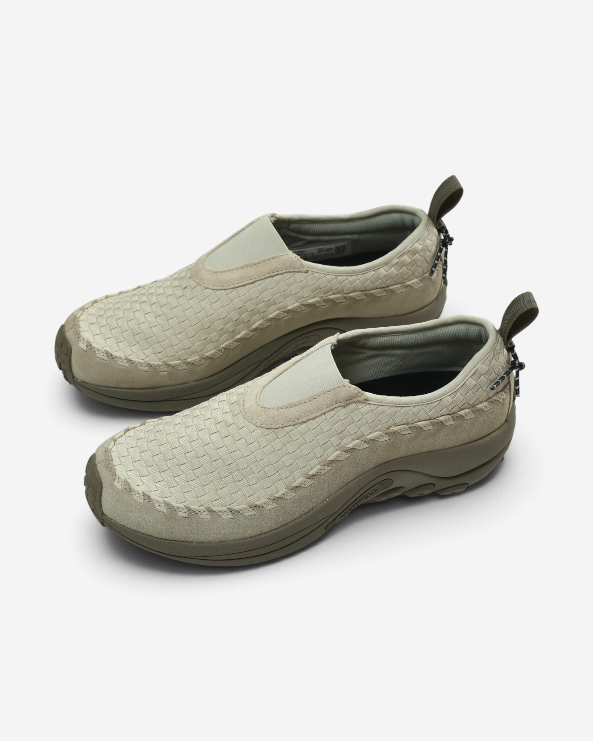 Бежево-зелені текстильні кросівки-сліпони Merrell з плетеним візерунком, замшевим захисним обідком біля підошви та петлею на п'яті.