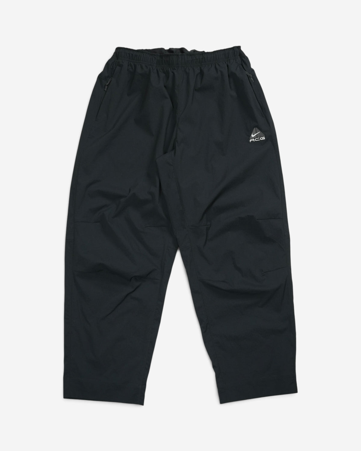 Чорні штани-трансформери Nike ACG Black Iguana з еластичним поясом, кишенями на блискавці та білим вишитим трикутним логотипом бренду.
