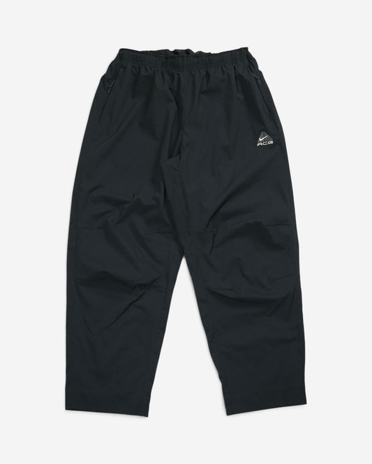 Чорні штани-трансформери Nike ACG Black Iguana з еластичним поясом, кишенями на блискавці та білим вишитим трикутним логотипом бренду.