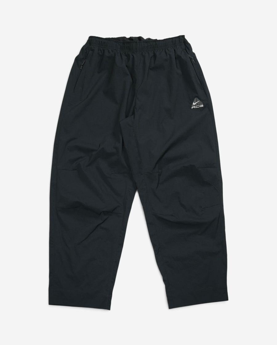 Чорні штани-трансформери Nike ACG Black Iguana з еластичним поясом, кишенями на блискавці та білим вишитим трикутним логотипом бренду.
