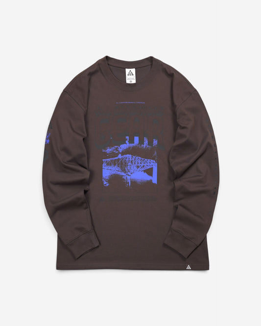  Темно-коричневий лонгслів Nike ACG Bridge of Gods Long-Sleeve T-Shirt з яскравим синім принтом моста на грудях та малюнками на рукавах.