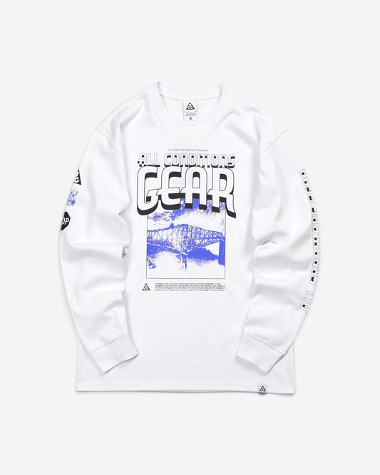  Білий лонгслів Nike ACG Bridge of Gods Long-Sleeve T-Shirt з великим синім графічним принтом моста, написом Gear та малюнками на рукавах.