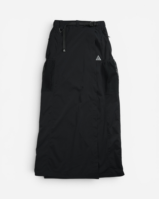 Чорна довга трекінгова спідниця Nike ACG Snowgrass із регульованим вбудованим ременем, бічними сітчастими кишенями та вишитим білим трикутником.