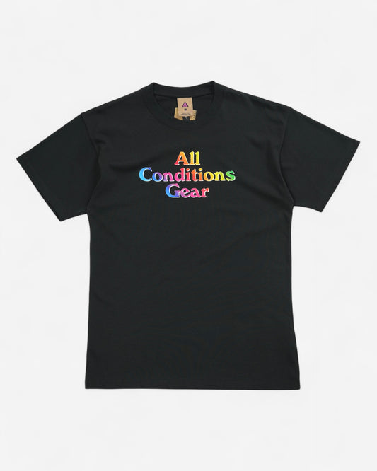 Чорна чоловіча футболка Nike ACG вільного крою з великим об'ємним написом All Conditions Gear у яскравих веселкових градієнтних кольорах по центру.