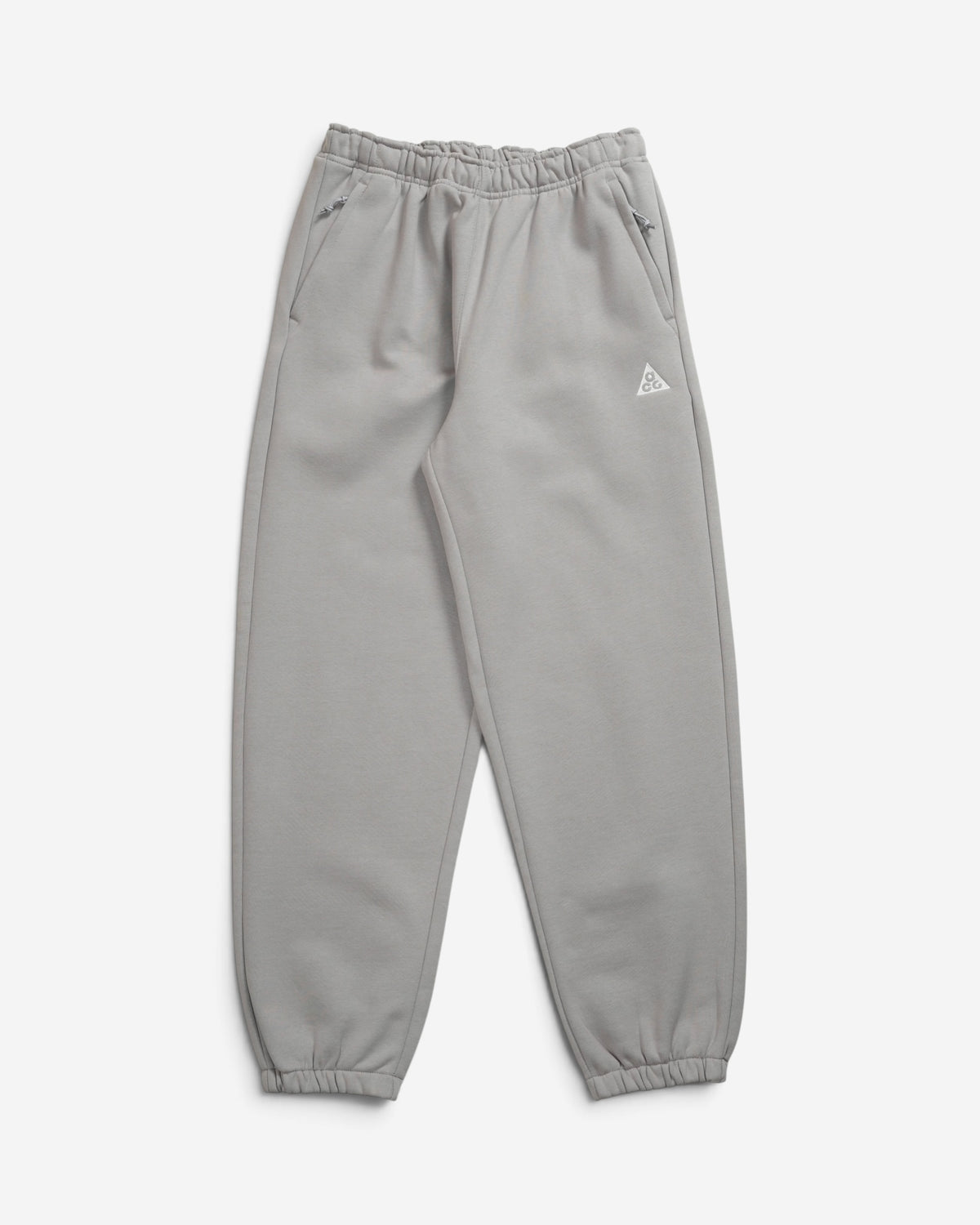 Чоловічі сірі спортивні штани джогери Nike ACG Tuff Fleece з вишитим білим трикутним логотипом на стегні.