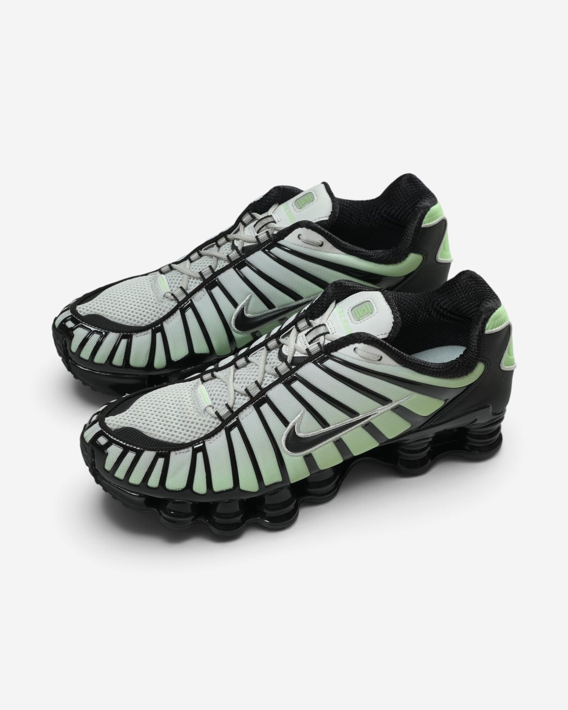 Світло-зелені чоловічі кросівки Nike Shox TL із чорними лініями каркаса, чорним вишитим логотипом та впізнаваною пружинною підошвою.