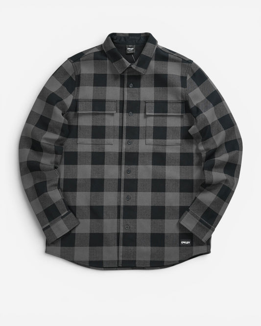 Чорно-сіра картата сорочка-жакет Oakley Bear Cozy Flannel з довгим рукавом, двома нагрудними кишенями та невеликим прямокутним патчем бренду знизу.