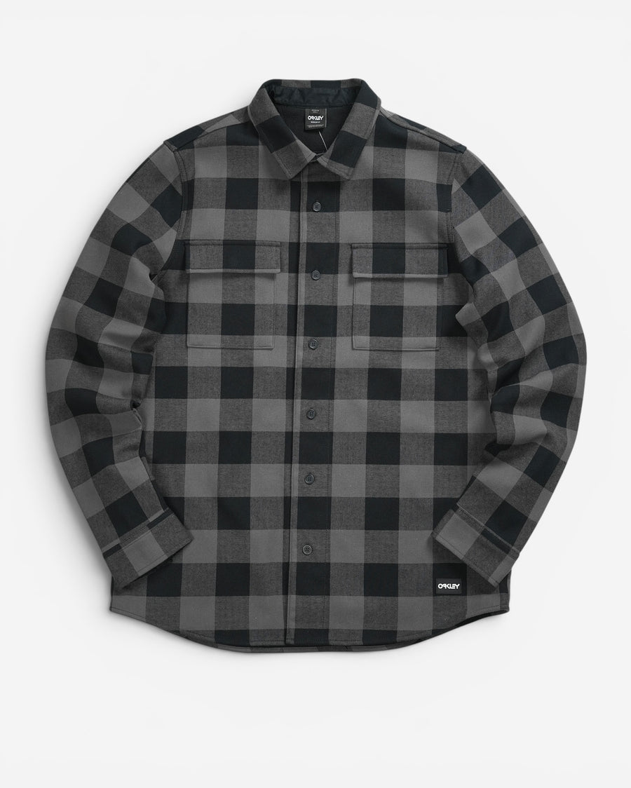 Чорно-сіра картата сорочка-жакет Oakley Bear Cozy Flannel з довгим рукавом, двома нагрудними кишенями та невеликим прямокутним патчем бренду знизу.