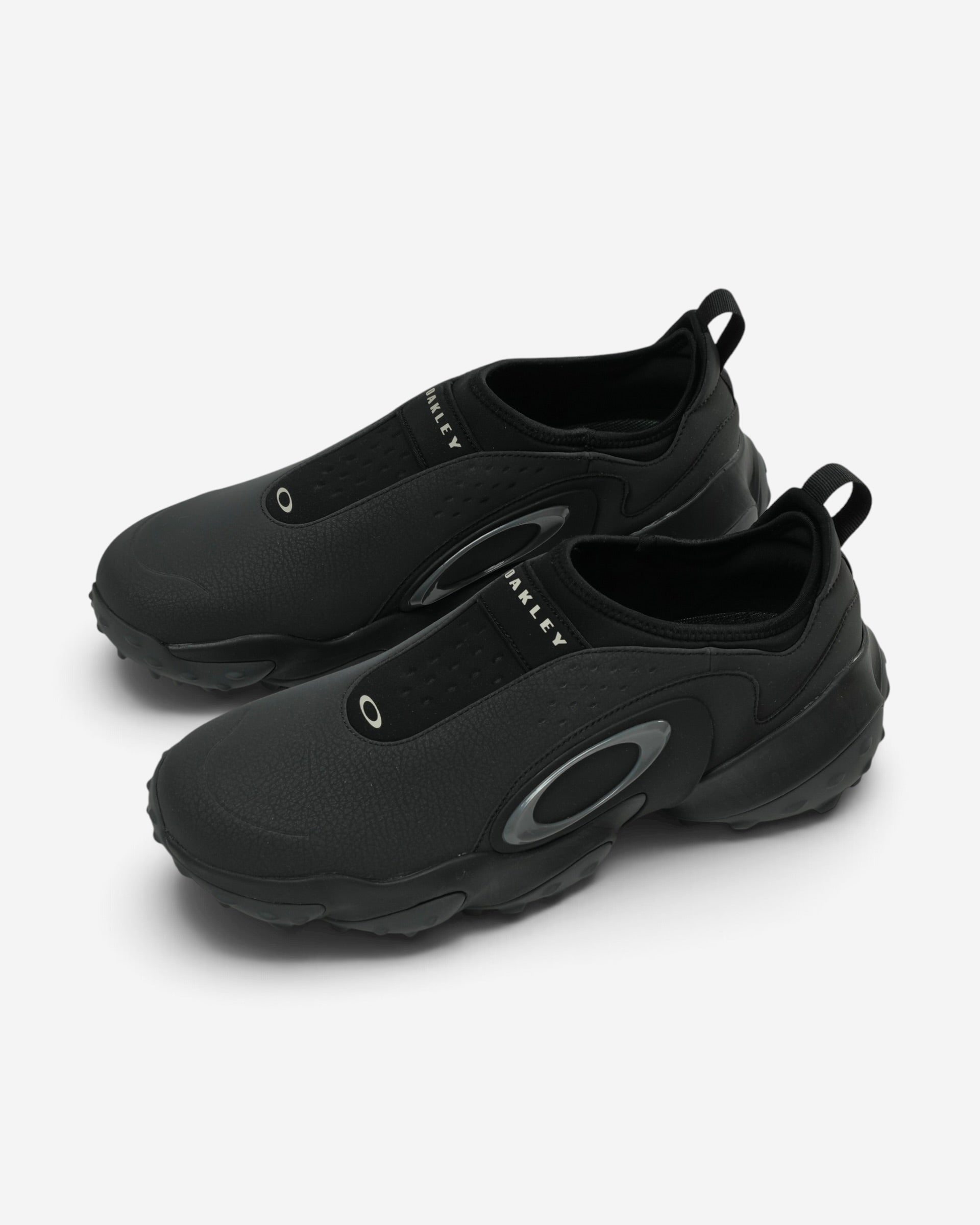 Повністю чорні чоловічі кросівки-сліпони Oakley Edge Icon з масивною об'ємною підошвою, неопреновим верхом та сірим логотипом-еліпсом.