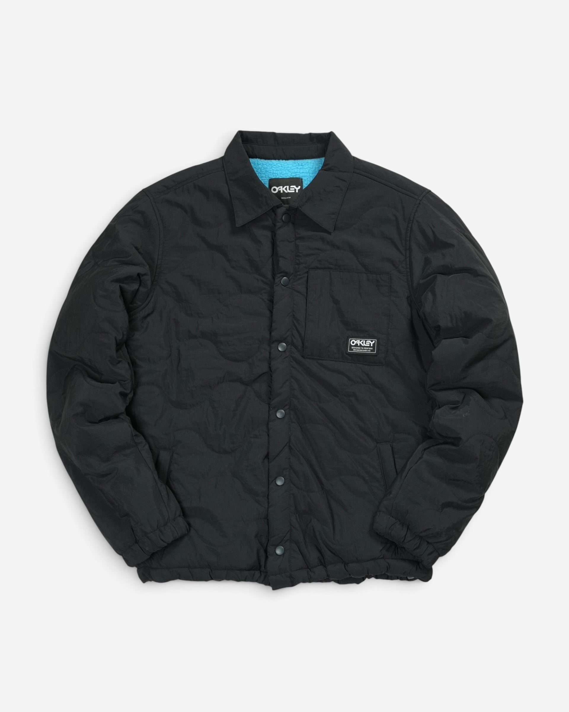 Стьобана куртка-сорочка Oakley Quilted Sherpa Jacket чорного кольору з відкладним коміром, кнопками та фірмовою нашивкою бренду на нагрудній кишені.