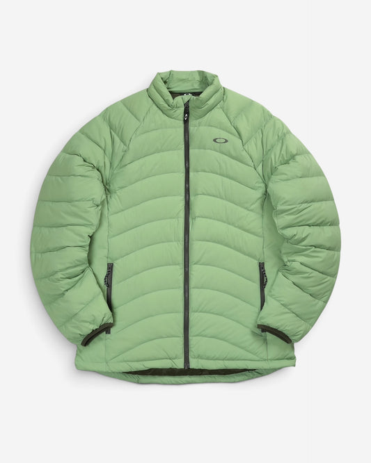Пуховик Oakley Snowbound Packable Down Puffy Jacket світло-зеленого кольору New Jade з горизонтальним стьобанням, коміром-стійкою та логотипом на грудях.