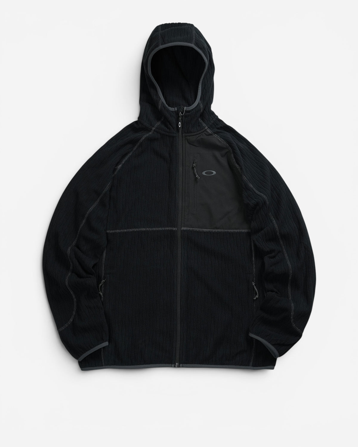 Чорна флісова куртка з капюшоном Oakley Vista Full Zip із текстильною накладкою з ріпстопу на лівій стороні грудей та вертикальною кишенею.