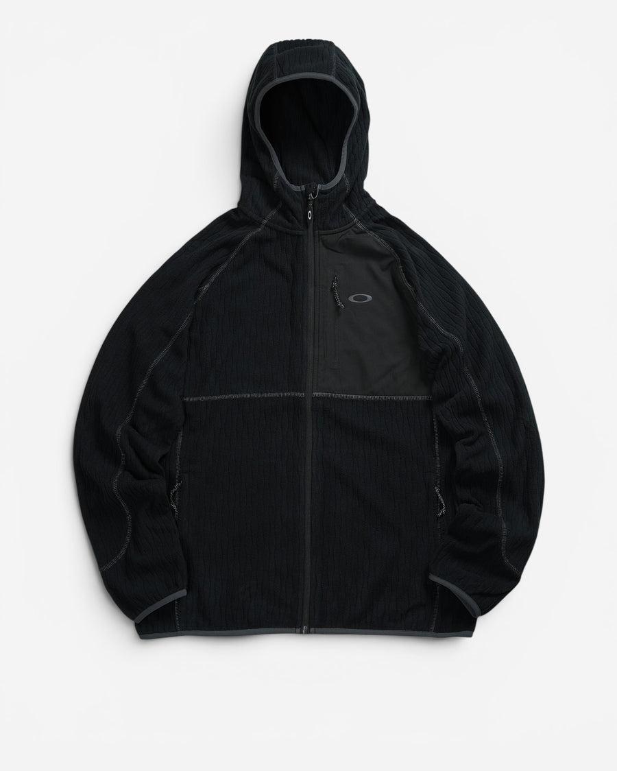 Чорна флісова куртка з капюшоном Oakley Vista Full Zip із текстильною накладкою з ріпстопу на лівій стороні грудей та вертикальною кишенею.