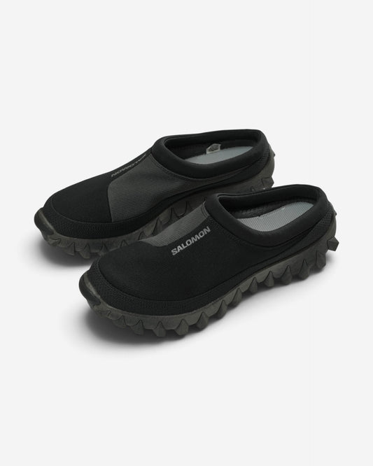Чорні чоловічі мюлі Salomon Snowclog із сірими текстильними вставками, білим логотипом бренду на підйомі та масивною зубчастою підошвою.