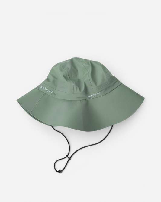 Світло-зелена аутдор-панама з широкими полями Snow Peak GORE-TEX Rain Hat із затяжкою-фіксатором на шнурку та світлими принтами брендів на тулії.