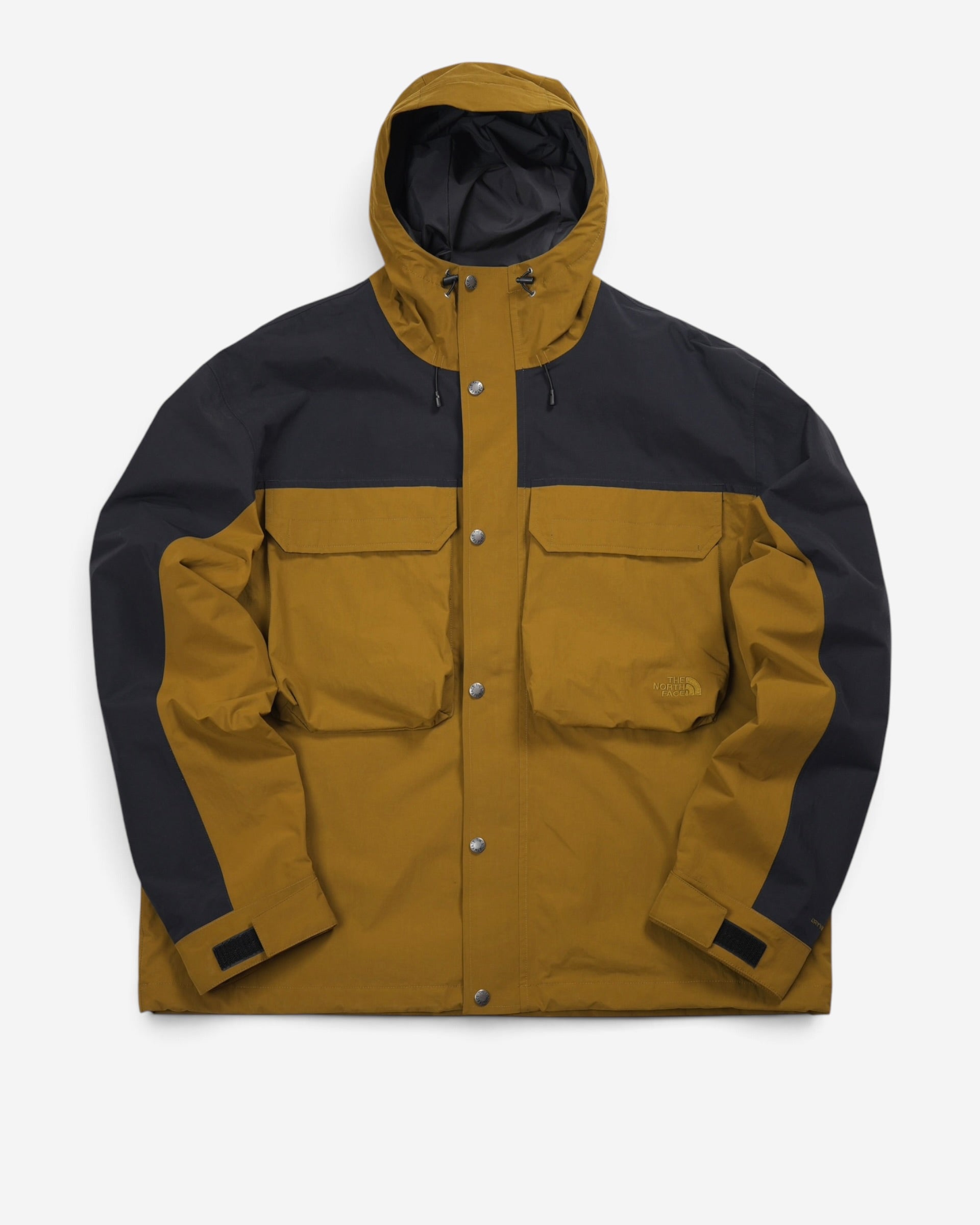 Гірчично-коричнева куртка-дощовик The North Face M66 Utility Rain Jacket з чорною кокеткою та рукавами, великими накладними кишенями і глибоким капюшоном.